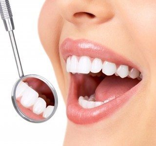 dental mirror reflecting white colored teeth without cavities