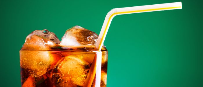 Glass of diet soda with ice and a green background