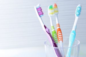 Toothbrushes shown together in a glass