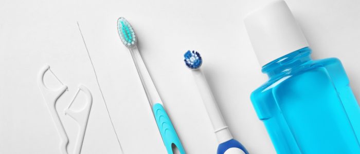 Oral hygiene tools laid out on a white background