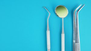 three dentistry tools on a blue background