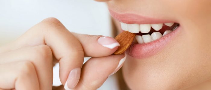 woman front teeth eating almond after a cavity filling